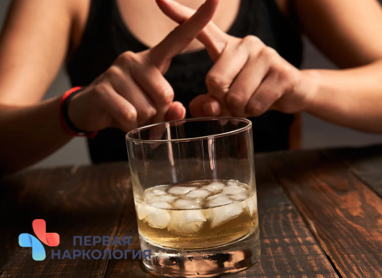Женщина отказывается от бокала с алкоголем
